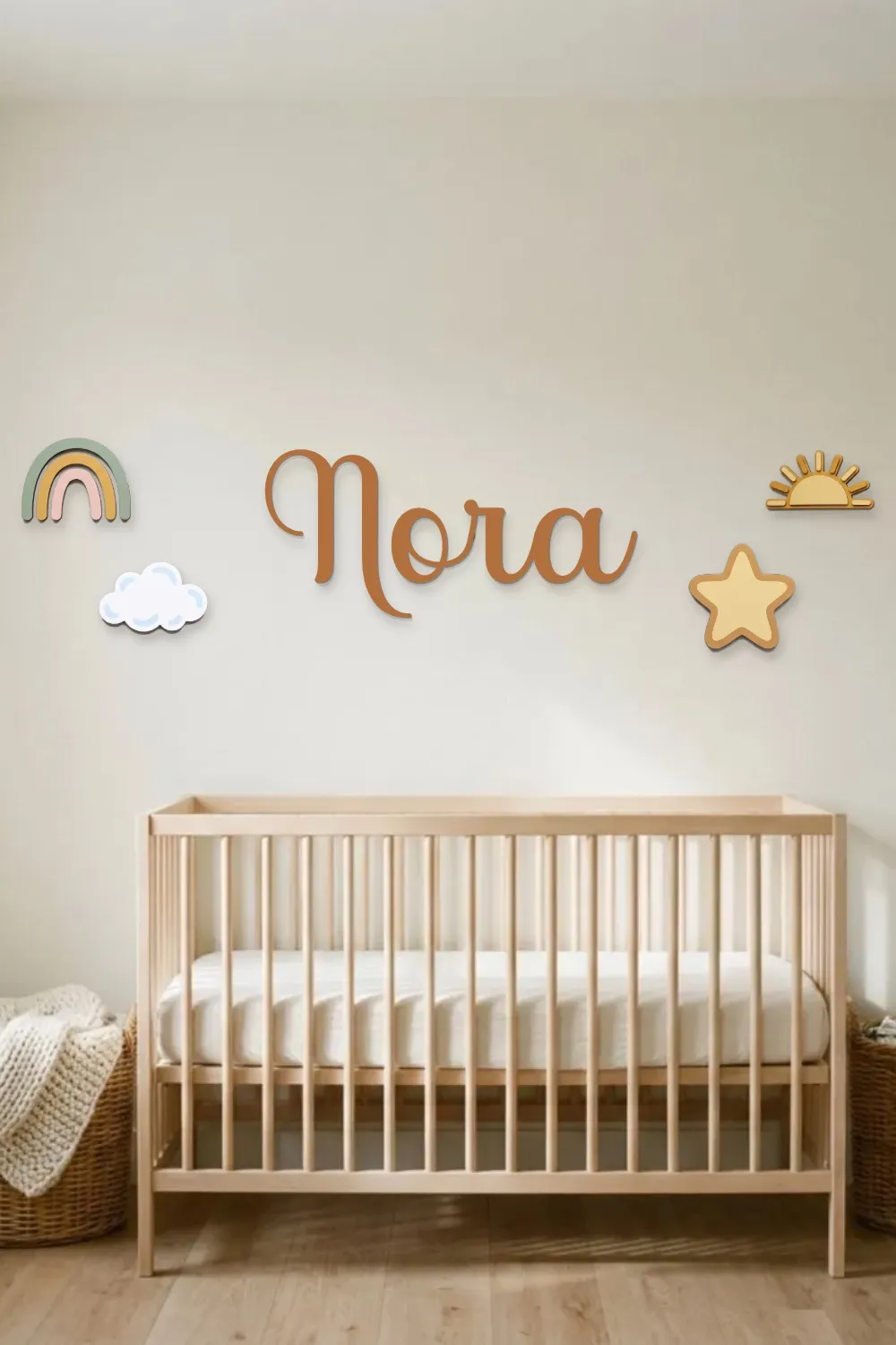 Nora name sign in caramel with a rainbow, cloud, star and sun, hung on the wall above a natural wood crib